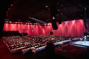 © Anja Koehler Werkstattbühne Parlamentbetischung, rot eingeleuchtete lange Vorhänge beim Wirtschaftsforum im Festspielhaus Bregenz © Anja Koehler