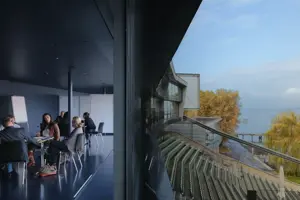 © Anja Koehler Workshopteilnehmer:innen sitzen in Gruppen in der Blauen Lounge mit Blick auf die Tribüne und den Bodensee © Anja Koehler