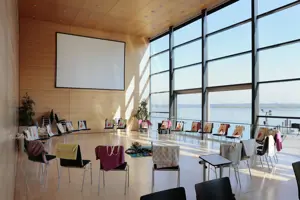 Ein großer Stuhlkreis mit bunten Decken über den Stuhllehnen und Leinwand im Seefoyer im Festspielhaus Bregenz © Anja Koehler