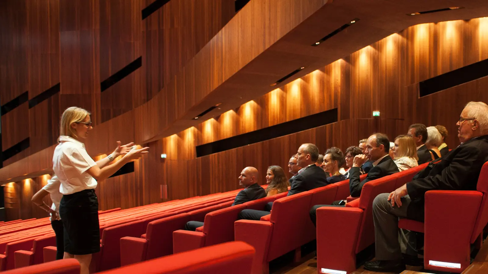 © pi grafik, Bregenzer Festspiele Ein Guide gestikuliert vor den im Großen Saal des Festspielhauses Bregenz sitzenden Führungsteilnehmer:innen © pi grafik, Bregenzer Festspiele