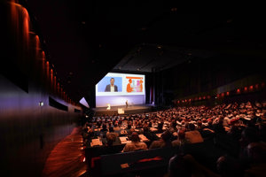 Vollbesetzter Großer Saal mit Parlamentbetischung und großer Leinwand und Redner auf der Vorbühne im Festspielhaus Bregenz