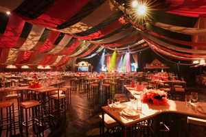 Rot-weiß eingeleuchtete, mit weißen gedeckten Tischen und Stühlen bestückte Werkstattbühne, im Festspielhaus Bregenz