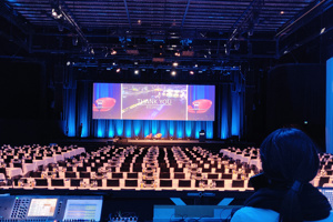 Technik-Mischpult und große Leinwand auf der hellblau eingeleuchteten Werkstattbühne im Festspielhaus Bregenz