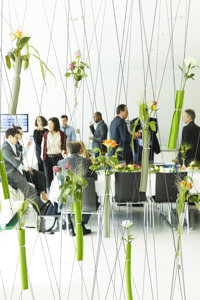 Kongressteilnehmer:innen zwischen bunten Blumen im Festspielhaus Bregenz