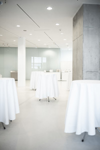 Weiß gedeckte Stehtische im hellerleuchteten Foyer 2 im Festspielhaus Bregenz