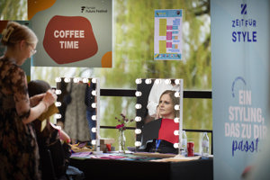 Eine Frau wird an einem Schminktisch frisiert im Seefoyer im Festspielhaus Bregenz