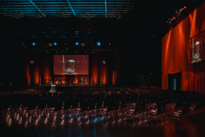 Stimmungsvoll warm eingeleuchtete Bühne vor leeren Stuhlreihen auf der Werkstattbühne im Festspielhaus Bregenz