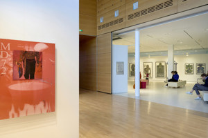 Ausstellungsbesucher:innen sitzen vor Gemälden bei der STAGE Bregenz 2024 im Foyer des Festspielhauses Bregenz