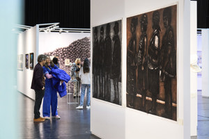 Ausstellungsbesucher:innen stehen vor Gemälden bei der STAGE Bregenz 2024 auf der Werkstattbühne im Festspielhaus