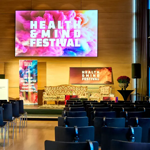 Ein niedrige Bühne mit Retro-Couch vor schwarzer Reihenbestuhlung im Seefoyer des Festspielhauses Bregenz © Anja Koehler